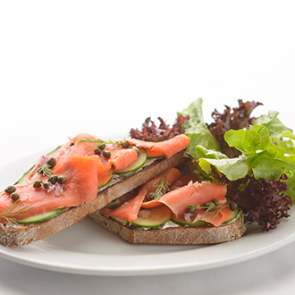Two slices of bread topped with salmon and capers.